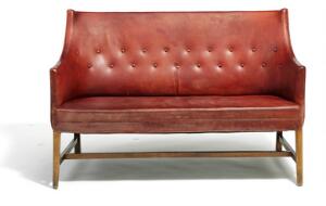 Frits Henningsen Fritstående to-personers sofa med ben af mahogni. Sider, sæde samt dybthæftet ryg betrukket med rødt skind. L. 130.