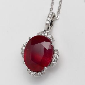 Halskæde med rubin- og diamantvedhæng af 14 og 18 kt. hvidguld prydet med oval facetslebet rubin omkranset af talrige brillantslebne diamanter.