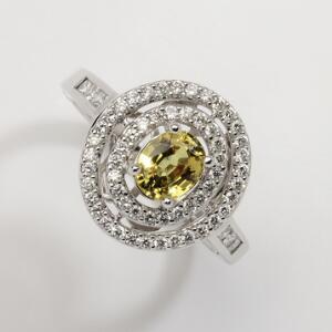 Safir- og diamantring af 18 kt. hvidguld prydet med oval facetslebet gul safir på ca. 1.08 ct. omkranset af talrige diamanter på i alt ca. 0.60 ct. Str. 54.