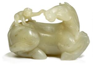 Figur af hvidgrå jade i form af liggende hest med abe på ryggen. 20. årh. L. 14 cm. H. 9 cm.