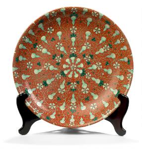 Kinesisk fad af porcelæn, dekoreret i emaljefarver med kalabsfrugter og blade på rødlig grund. Mærket Qianlong. Qing, 19. årh. Diam. 47 cm.
