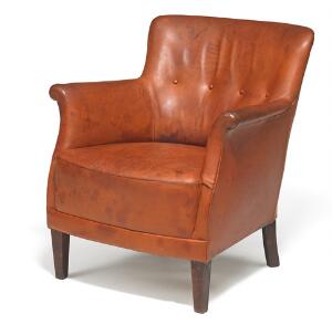 Fritz Hansen Lænestol opsat på tilspidsende ben af bejdset bøg. Sider, sæde samt dybthæftet ryg betrukket med originalt patineret naturskind.