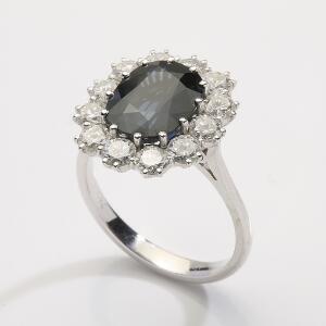 Safir- og diamantring af 18 kt. hvidguld prydet med oval facetslebet safir omkranset af talrige brillantslebne diamanter. Str. 55. Ca. 2006.
