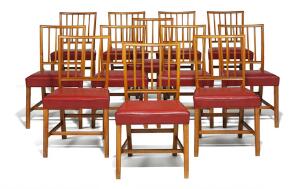 Jacob Kjær Sæt på 12 stole med profileret stel af valnød. Sæder betrukket med patineret rødt farvet skind. Udført hos snedkermester Jacob Kjær. 12