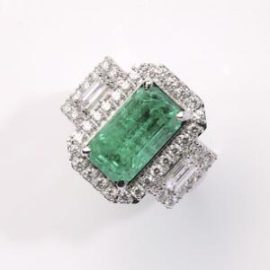 Smaragd- og diamantring af 18 kt. hvidguld prydet med smaragdslebet smaragd på ca. 5.41 ct. flankeret og omkranset af talrige diamanter på i alt ca. 1.18 ct.