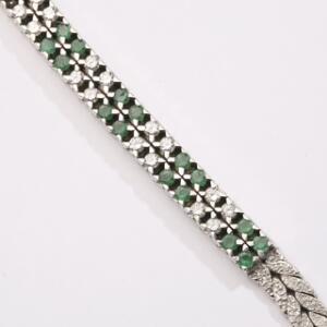 Smaragd-og diamantarmbånd af 14 kt. satineret hvidguld prydet med talrige facetslebne smaragder og brillantslebne diamanter. L. ca. 18,5 cm. Ca. 1950-60.