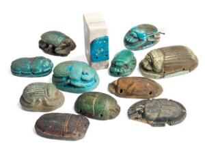 En samling på ti ægyptiske  fajance skarabæer samt vinge med turkis glasur monteret på en sten. 21.-30. dynasti, ca. 1100-350 f.Kr. 11
