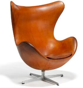 Arne Jacobsen Ægget. Hvilestol med helstøbt, profileret stamme af aluminium. Sider, ryg samt løs sædehynde betrukket med patineret cognacfarvet skind.