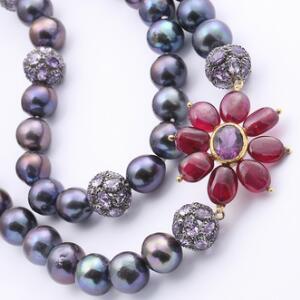 Perle- og rubinhalskæde af delvist forgyldt sølv med barokke ferskvandskulturperler, rubiner og perler af sølv prydet med  ametyster. L. ca. 92 cm.