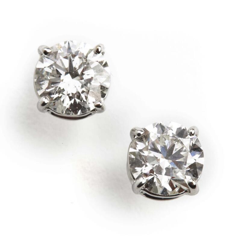 A pair of diamond ear studs each set with a brilliant-cut diamond weighing...