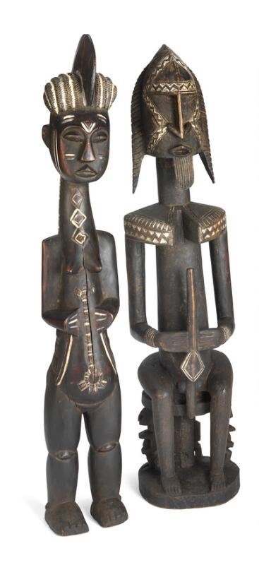 Two large ancestor figures of carved black patinated wood with traces of...