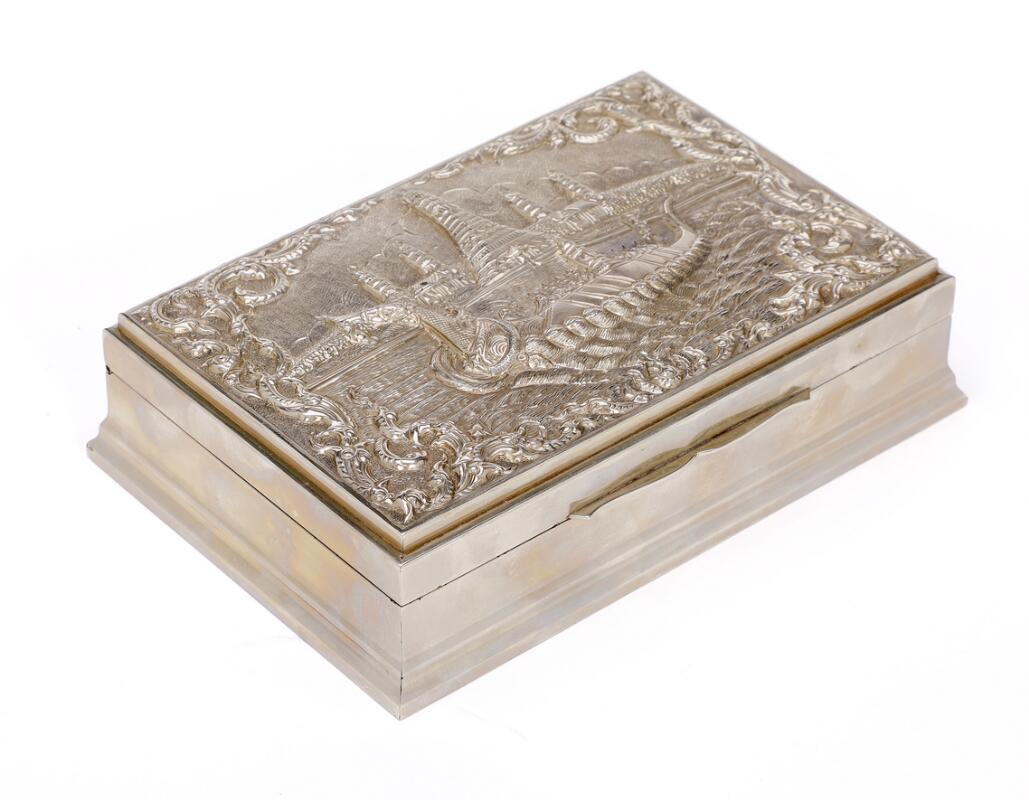 A silver cigarette box lined with faux bois, lid chased with prespectus ...