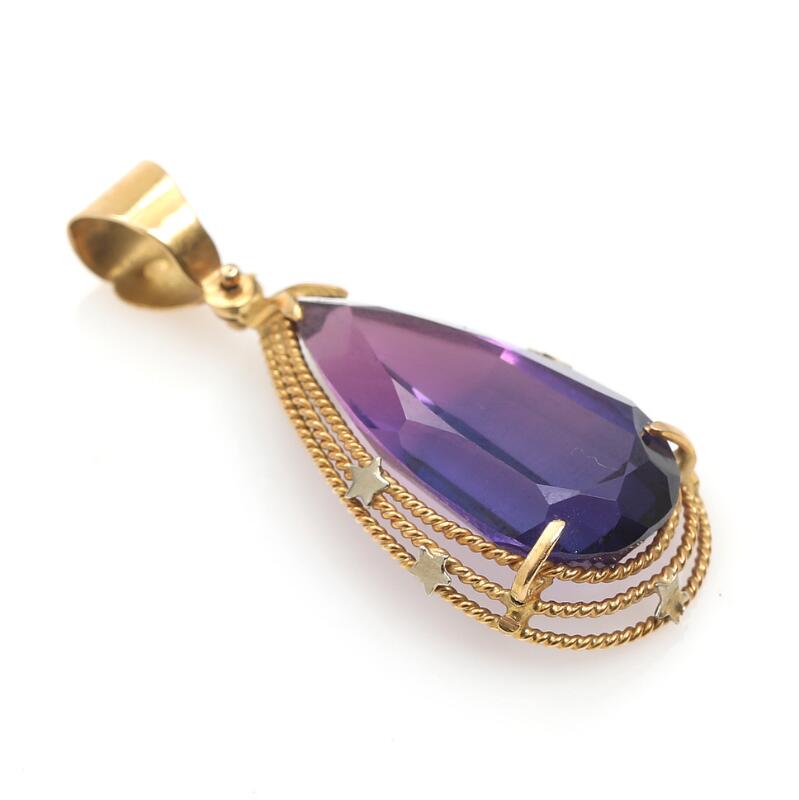 A sapphire pendant set with a faceted synthetic purple sapphire, mounted in...
