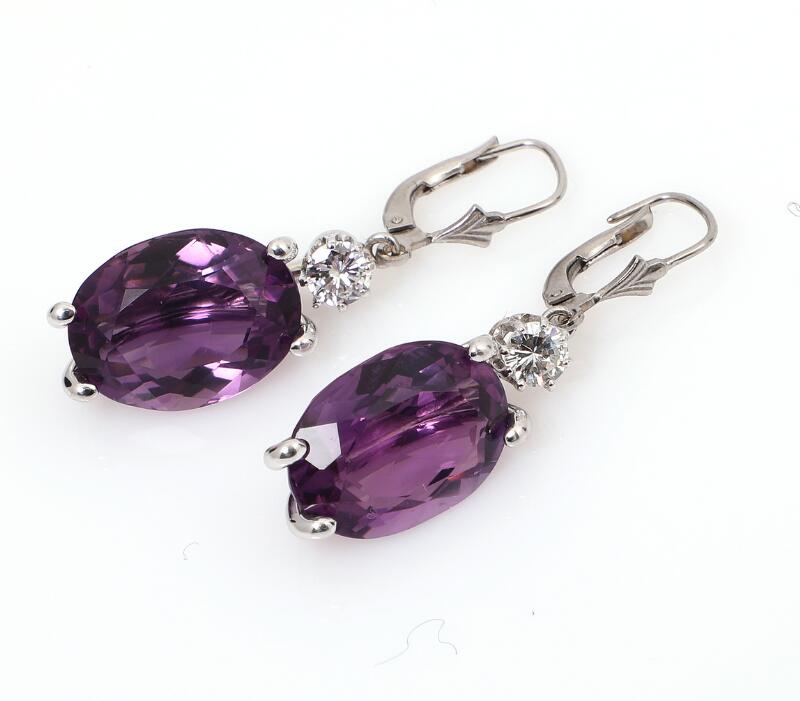 A pair of amethyst and diamond ear pendant each set with an oval-cut...