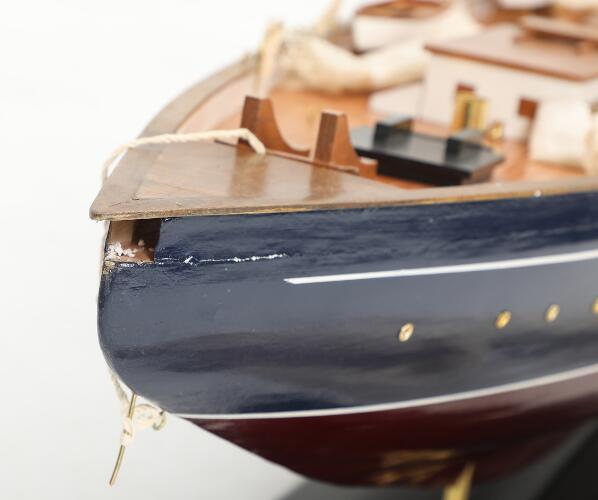 A wooden model ship in the shape of a three-masted sailing boat ...