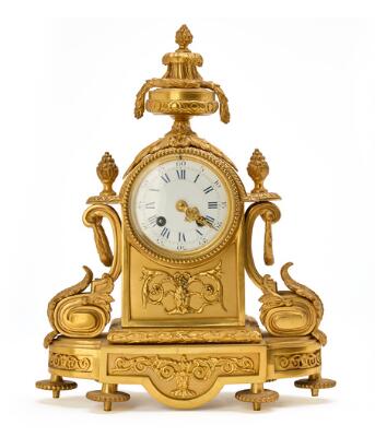 A French Louis XVI style mantel clock of gilded bronze with white