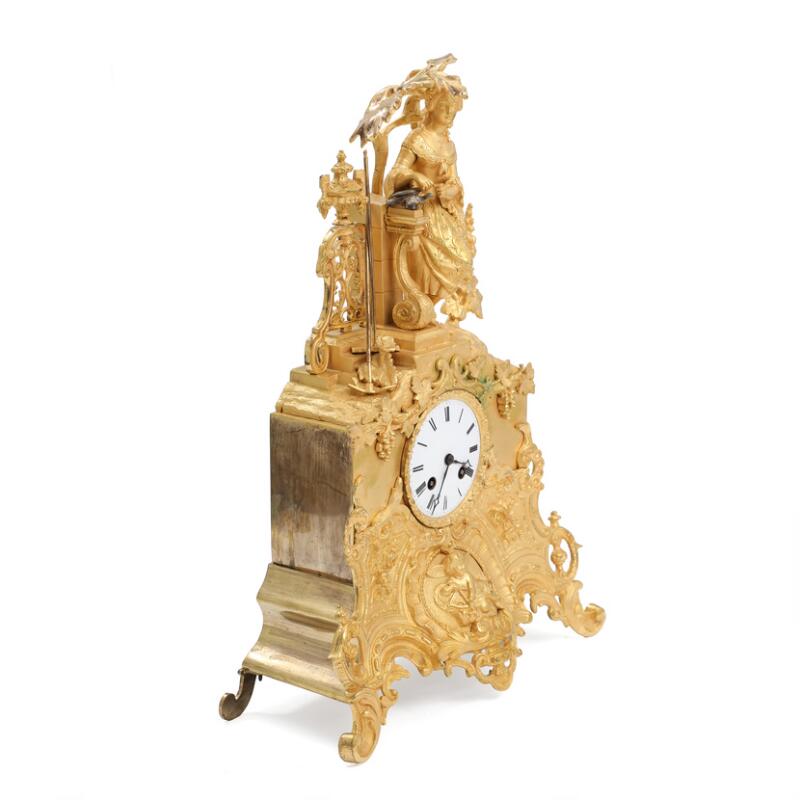 French mantel clock of gilded bronze, decorated with a standing