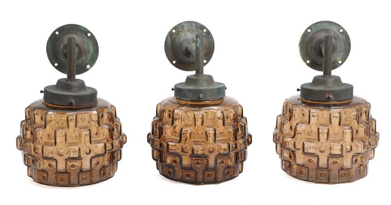 Three outdoor wall lamps of patinated copper, shades of smoke coloured glass. 1950–60s. H. 38. L. 28. Diam. 20 cm. (3)