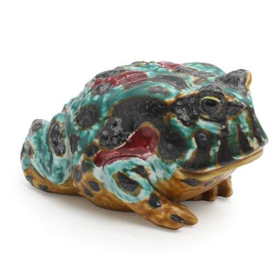 Faience figure in the form of a toad. Decorated in green, ochre and black glazes with red elements. Signed JG. 3471. Royal Copenhagen. H. 8.5. L. 16 cm.