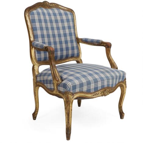 Louis XVI style armchair of gilded wood, upholstered in blue-checked fabric. 19th century.