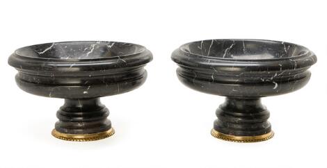 A pair of tazze in black marble. Lower edge mounted with gilt bronze. 20th/21st century. H. 23 cm. Diam. 36 cm. (2)