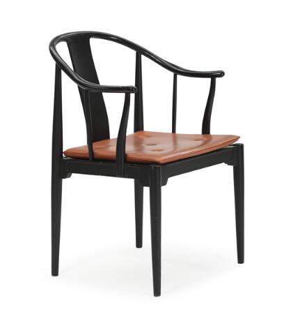 Hans J. Wegner: "China-Chair". Armchair with blacklacquered ash frame, loose cushion with brown leather. Manufactured by Fritz Hansen.