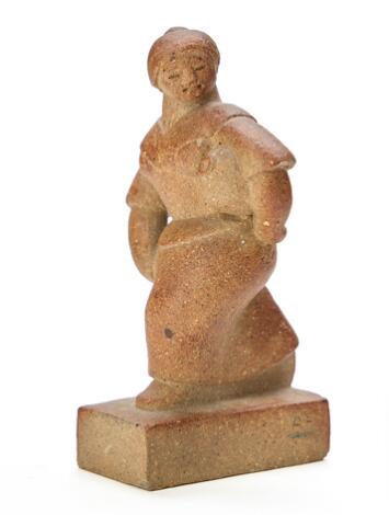 Adam Fischer: A small unglazed stoneware sculpture, modelled as a woman carrying a jar. H. 13 cm.