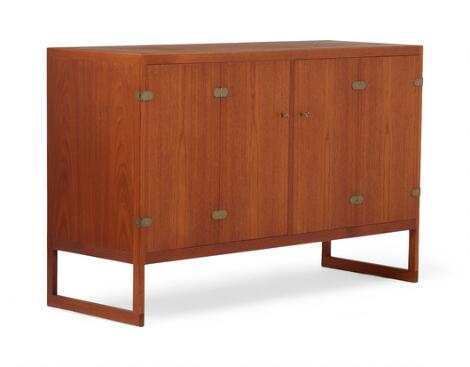 Børge Mogensen: A teak sideboard mounted on runner legs, front with two foldable doors, interior with trays and shelves, brass fittings.