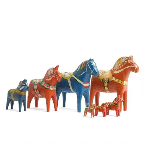 Collection of seven Dala horses of carved wood, decorated in orange-red and blue. 20th century. H. 3-13 cm. (7)