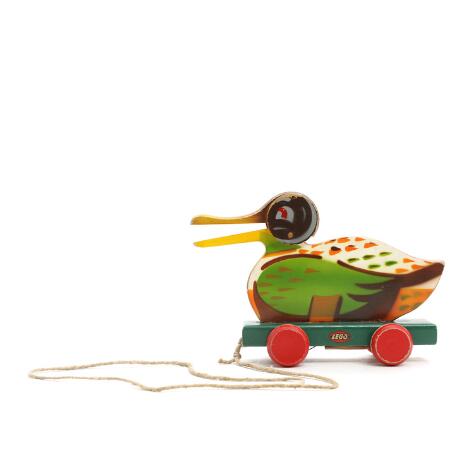 LEGO: A painted wooden pull duck on four wheels. Manufactured and marked by LEGO. L. 24. H. 16 cm.