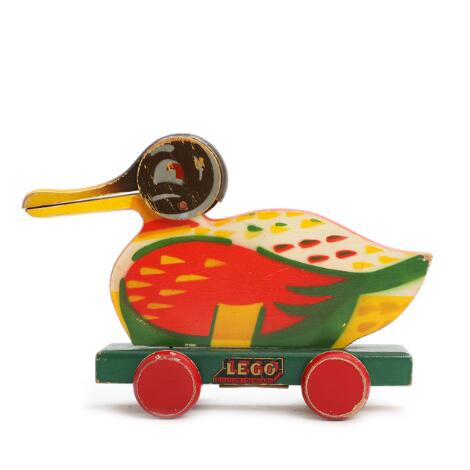 LEGO: A paint wooden pull duck on wheels, marked “Lego, Billund Denmark”. H. 16. L. 24 cm.