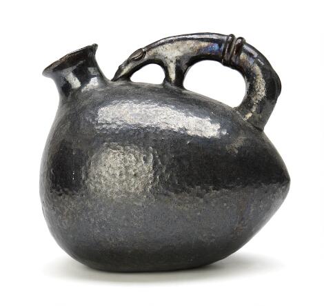 Gertrud Vasegaard, Lisbeth Munch-Petersen: An earthenware pitcher with animal-shaped handle. Decorated with dark brown metallic, glaze.